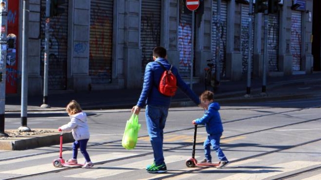 Bimbi portati dal papà a fare una passeggiata (Ansa)