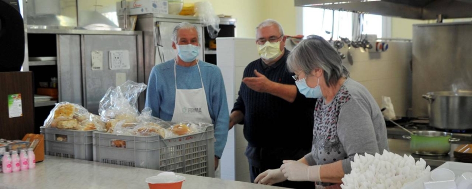 No centro, Don Domenico Bedin dentro da cantina da associação "Viale K"